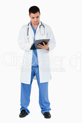 Portrait of a doctor writing on a clipboard