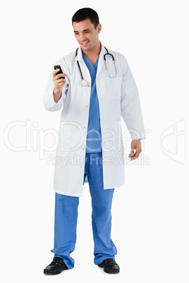 Portrait of a doctor dialing on his mobile phone