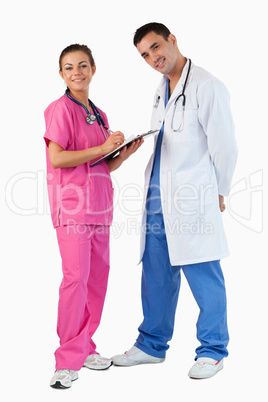 Portrait of a doctor talking while a nurse is taking notes