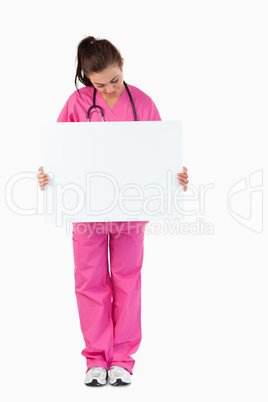 Portrait of a brunette doctor holding a blank panel