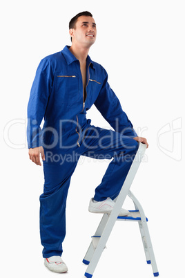 Portrait of a mechanic climbing on a stool