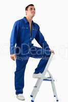 Portrait of a mechanic climbing on a stool