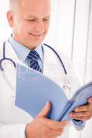 Mature doctor male look down in document