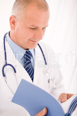 Mature doctor male look down in document