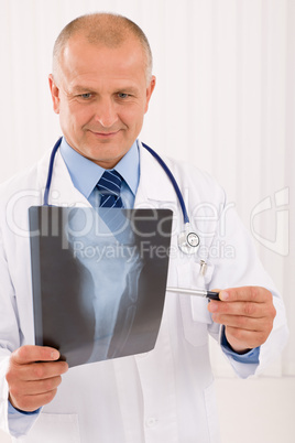 Mature senior doctor male look down x-ray