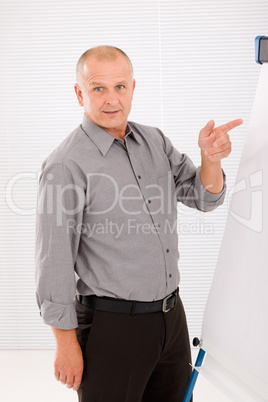 Mature businessman pointing at empty flip chart