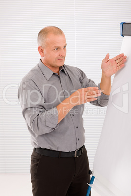 Mature businessman pointing at empty flip chart