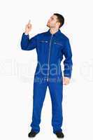 Young mechanic in boiler suit pointing up