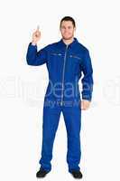 Smiling young mechanic in boiler suit pointing up
