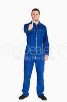 Smiling young mechanic in boiler suit showing his wrench