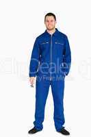 Smiling young mechanic in boiler suit holding a wrench