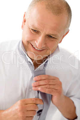 Business mature man smiling tie a tie