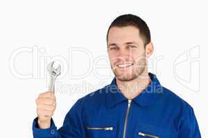 Smiling young mechanic holding his wrench