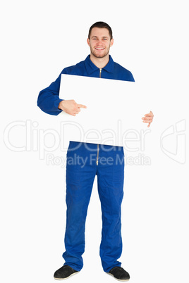 Smiling young mechanic in boiler suit pointing on banner in his
