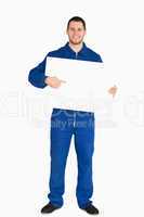 Smiling young mechanic in boiler suit pointing on banner in his