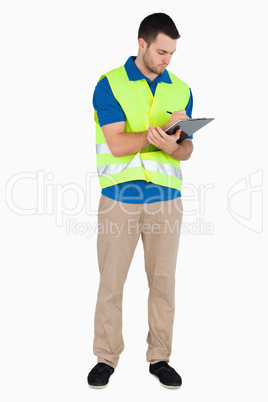 Young male with safety jacket taking notes
