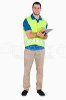 Smiling young male with safety jacket taking notes