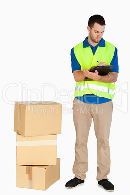 Young delivery man filling in delivery note