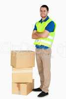 Smiling young delivery man with arms folded