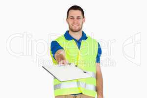 Smiling young delivery man asking for signature on delivery bill