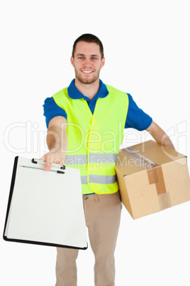 Smiling young delivery man handing over delivery bill for signat