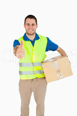 Smiling young delivery man giving approval