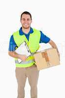 Smiling young delivery man with parcel and delivery note