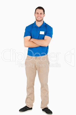 Smiling young salesman with arms folded