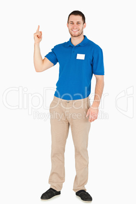 Smiling young salesman pointing upwards