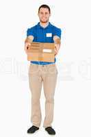 Smiling young salesman handing over parcel