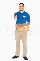 Smiling young salesman with parcel giving thumb up