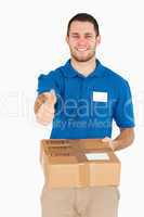 Smiling young salesman with packet giving thumb up