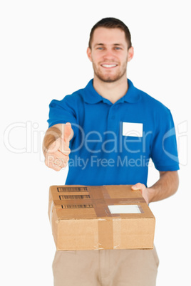 Parcel handed over by smiling young salesman giving thumb up