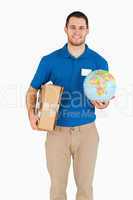 Smiling young salesman with parcel and globe in his hands
