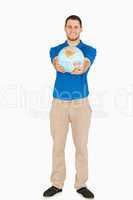 Smiling young salesman presenting globe in his hands