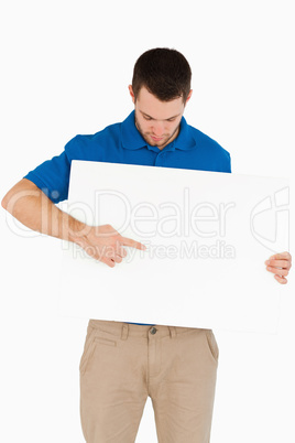 Young salesman pointing at banner he is holding