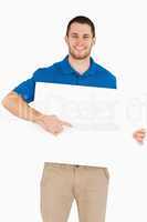Smiling young salesman pointing at banner in his hands