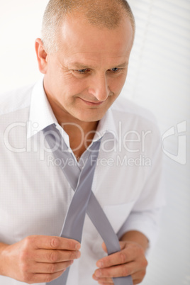 Business mature man handsome tie a tie