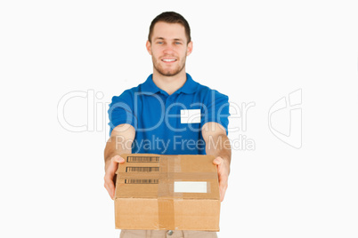 Smiling young sales assistant handing over parcel