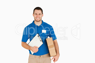 Smiling young salesman with parcel and clipboard