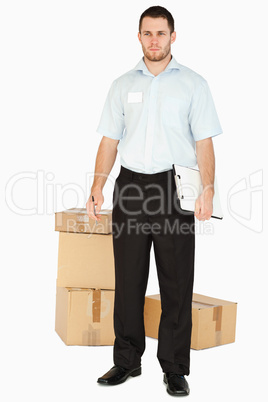 Young post employee with parcels and clipboard