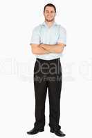 Smiling young post employee with arms folded