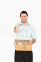 Smiling young post employee handing over parcel while giving thu