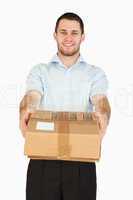 Smiling young post employee handing over parcel