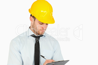 Young lead worker taking notes on his clipboard