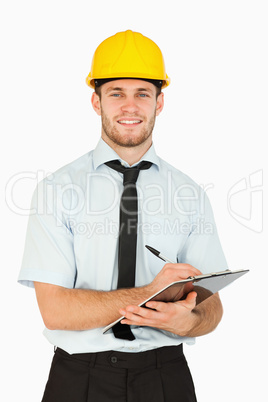 Smiling young lead worker taking notes on his clipboard