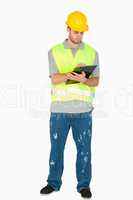 Young construction worker taking notes on his clipboard