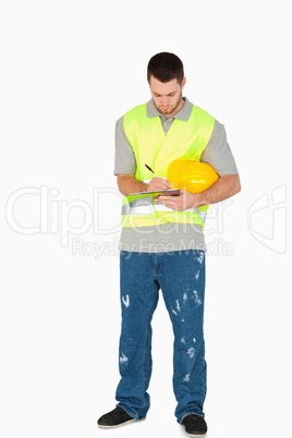 Young construction worker taking notes