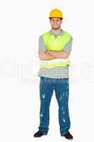 Smiling young construction worker with arms folded