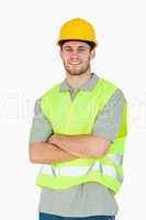 Smiling young construction worker with folded arms